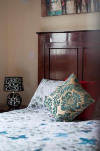 a bed with a wooden headboard and a pillow on it at Westlands Place -Fahari Delux , 1 bedroom Apartment in Nairobi