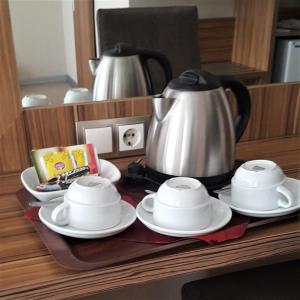 a tea kettle and saucers on a table at Buyuk Hotel in Kayseri