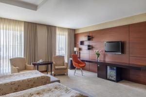 a living room filled with furniture and a tv at Point Hotel Baku in Baku