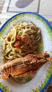 a plate of food with pasta and fish on it at Villa Salvatore in San Leone