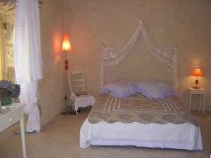 a bedroom with a canopy bed with purple pillows at Mas Casta Néa in Thueyts