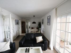 uma sala de estar com um sofá preto e uma mesa em Apartamento Maraka Playa Castelldefels em Castelldefels