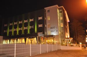 un hôtel la nuit avec une clôture devant lui dans l'établissement Hotel Aleluia, à Fátima