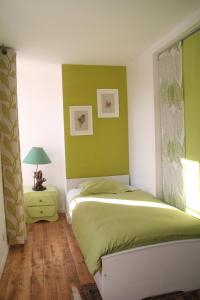 a bedroom with a bed and a green wall at Ar Litorienn in Paimpont