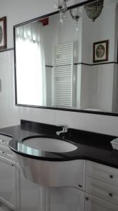a white sink sitting under a mirror in a bathroom at Hotel Villa Luisa in Rapallo