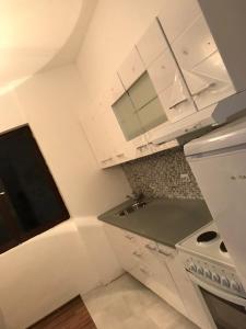uma cozinha com armários brancos e um fogão em Villa Rose Ann em Rogoznica