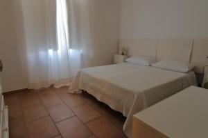 a bedroom with two beds and a tiled floor at Guest House Li Minnanni in Olbia