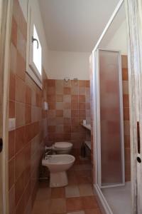 a bathroom with a toilet and a sink and a shower at Guest House Li Minnanni in Olbia
