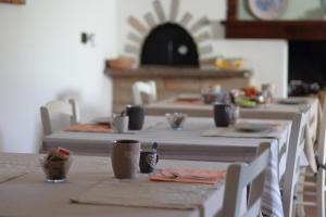 a long table with white tables and chairs in a kitchen at Guest House Li Minnanni in Olbia