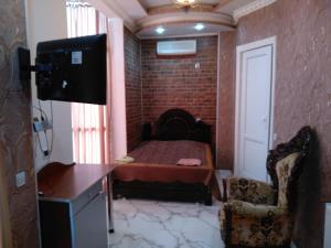 ein kleines Zimmer mit einem Bett und einem Stuhl in der Unterkunft Edemi in Kutaissi