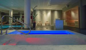 a swimming pool with a blue tub in a room at Hotel Formula International in Rosolina