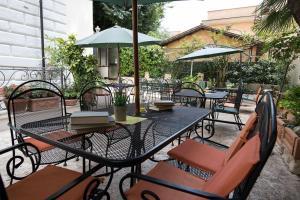 a table with chairs and an umbrella on a patio at Hotel Villa Delle Rose in Rome