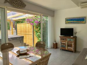 a living room with a table and a television at Villa L'Amiraute in Agde