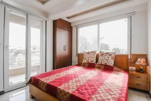 ein Schlafzimmer mit einem großen Bett und großen Fenstern in der Unterkunft Lila's Abode - Homestay in Jaipur