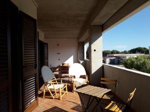 eine Terrasse mit Stühlen und Tischen auf dem Balkon in der Unterkunft La ginestra gialla in Albinia