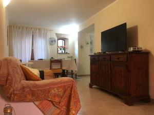 a living room with a flat screen tv on a wooden cabinet at Casa vacanze Elena in Rometta