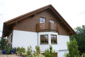 a house with a balcony on top of it at Vreni's Gästezimmer in Himmelried +12 photos