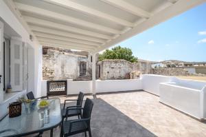 un patio al aire libre con mesa y sillas en My Family Home en Glinado Naxos