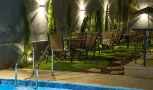 a row of tables and chairs next to a swimming pool at Shams Alweibdeh Hotel in Amman
