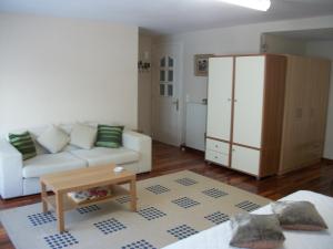 a living room with a white couch and a cabinet at Studio Elli in Zakynthos Town