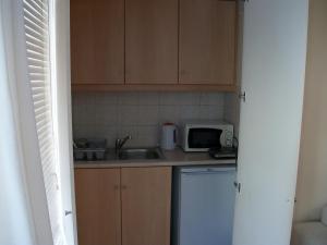 a small kitchen with a sink and a microwave at Studio Elli in Zakynthos Town