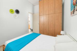 a bedroom with a white bed and wooden cabinets at Maximos Sea & The City in Rhodes Town