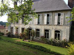 an old brick house with flowers in the yard at Château de Ricquebourg in Maresquel