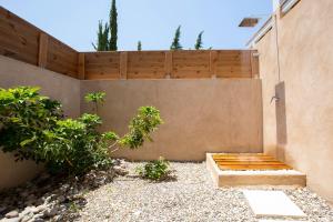 einen Garten mit einer Holzbank neben einer Wand in der Unterkunft Ionian Horizon Villas in Tsoukaladhes