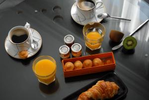 a table with a breakfast of orange juice and croissants at The Sleeping Lion in Paris