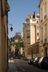 a city street with cars parked on the street at The Sleeping Lion in Paris