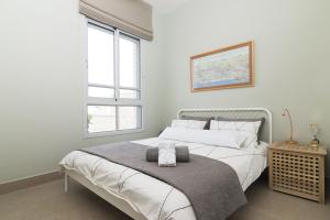 a bedroom with a large white bed and a window at Allenby 36 Bauhaus Residence 5 Stars in Tel Aviv