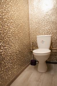 a bathroom with a toilet and a tiled wall at Scandinavian Poltava Apartments with 2 rooms, 3 beds 1 sofa in Poltava