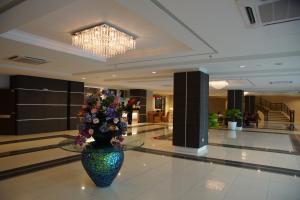 a lobby with a vase of flowers on the floor at MH Sentral Hotel Sg Siput in Ipoh