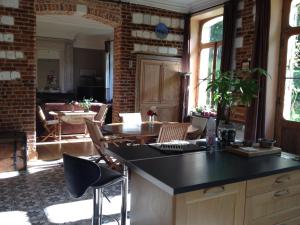 a kitchen and living room with a table and chairs at Château de Ricquebourg in Maresquel