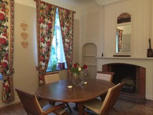 a dining room with a table and a fireplace at Château de Ricquebourg in Maresquel +20 photos