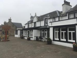 a group of buildings with a table in the courtyard at Novar Arms Hotel in Evanton