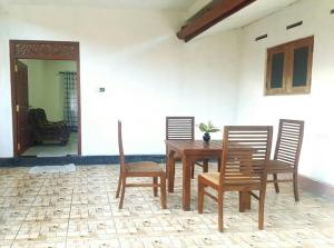 een houten tafel en stoelen in een kamer bij Sanithu Homestay Galle in Galle