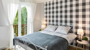 a bedroom with a bed and a window at Apartament na Wierchu zarezerwuj na podhalami pl in Bukowina Tatrzańska