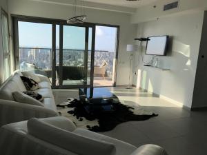 ein Wohnzimmer mit einem Sofa und einem TV in der Unterkunft Apartment "Style City" With Sea View in Bat Yam