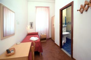 a small room with a bed and a bathroom at Hotel Timiama in Peschici