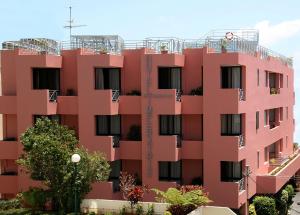 a pink building with plants on the balconies at Aparthotel Imperatriz in Funchal