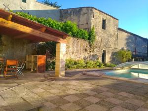 um pátio com uma piscina e um edifício em Grès Vaillant em Saint-Polycarpe