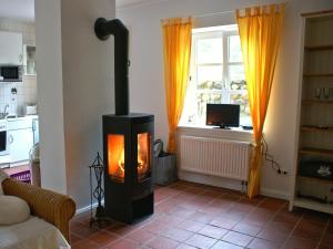 a living room with a wood stove in front of a window at Quaint Apartment in Semlow Germany with Garden in Semlow