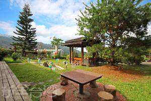 una mesa de picnic en un parque con cenador en 華山禾園親子民宿 en Gukeng