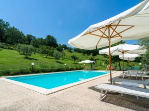 basen z parasolem i 2 krzesłami oraz stołem i parasolem w obiekcie Farmhouse in Umbria with Pool & Views w mieście Biscina