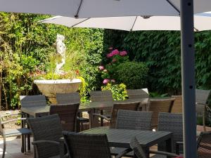 a patio with tables and chairs with a fountain at Come Inn in Neufch&acirc;tel-en-Bray