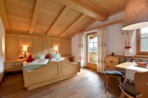 a bedroom with a bed and a table with chairs at Koasa Chalet in Going am Wilden Kaiser