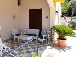 weranda z krzesłami, stołem i drzwiami w obiekcie Villa Belvedere Michelle w mieście Trappeto