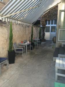 a patio with tables and chairs under a roof at Hotel Barbarossa in Karlsruhe