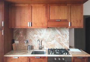a kitchen with wooden cabinets and a sink at Appartamenti fronte mare in Castiglioncello